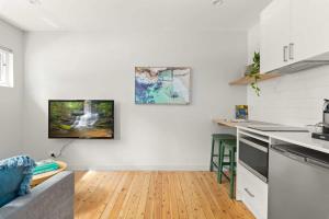 悉尼Modern 1-Bed Pad Minutes Away from Coogee Beach的厨房拥有白色的墙壁和木地板