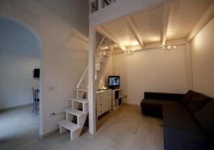 马里纳·迪·比萨La Casetta Del Mare in Toscana的客厅配有高架床和沙发