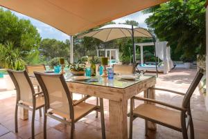 圣若法尔萨克鲁Villa Claudia - Ibiza的庭院里配有桌椅和遮阳伞