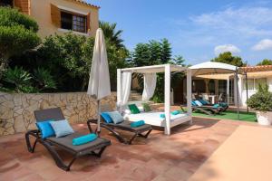 圣若法尔萨克鲁Villa Claudia - Ibiza的庭院配有床、椅子和遮阳伞