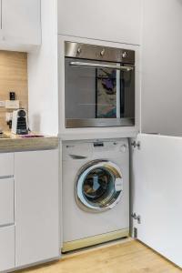 墨尔本Contemporary 1-Bed in the Heart of St Kilda的白色厨房里的洗衣机和烘干机