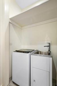 墨尔本Modern 2-bed St Kilda Apartment Near Shops的一间带水槽和炉灶的小厨房