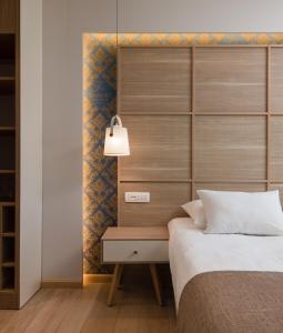图彻皮塔玛里斯酒店的一间卧室配有一张带木制床头板的床