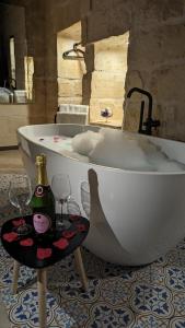 纳杜尔Sea Holly Gozo的浴缸配有2杯和1瓶香槟