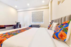 斋浦尔FabHotel Pravaasam Residency的一间卧室设有一张大床和一个窗户。