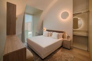 米兰NH Collection Milano CityLife的卧室配有白色的床和步入式淋浴间。