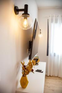 坎加斯德穆拉索A Casa Das Letras的一张带灯和花瓶的白色书桌