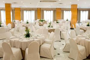 雷乌斯NH雷乌斯城市酒店的宴会厅配有白色的桌子和白色的椅子