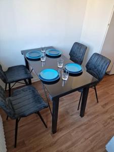 哥德堡Lugn och skön lägenhet centralt.的一张桌子,上面有四把椅子和蓝色的盘子