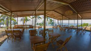 美娜多Bobocabin Bunaken Hills, Manado的海滩上带桌椅的餐厅