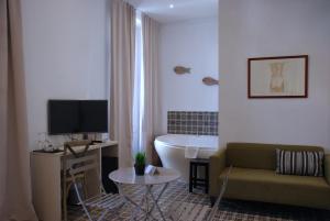瓦伦西亚圣洛伦索精品酒店的带沙发、电视和浴缸的客厅