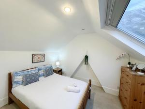 伦敦Lovely 3 bedroom maisonette with private roof terrace in Hammersmith的一间卧室设有一张床和一个窗口