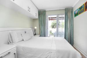 约翰内斯堡Corner House large 1 bedroom apartment的卧室设有一张白色大床和一扇窗户。