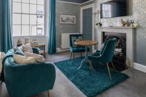 惠特比海格特楼住宿加早餐旅馆的客厅配有蓝色椅子和壁炉