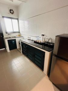 尼兹瓦السمو ALSMOU للشقق الفندقية的厨房配有黑色台面和冰箱
