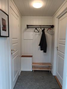 克里斯蒂安桑Guest house close to Kristiansand的带衣帽架和门的衣柜的房间