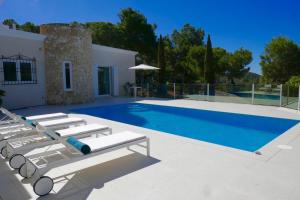卡拉隆加Villa Dream - Santa Eulalia的一座房子旁带躺椅的游泳池