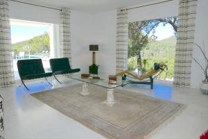 卡拉隆加Villa Dream - Santa Eulalia的客厅配有玻璃桌和椅子