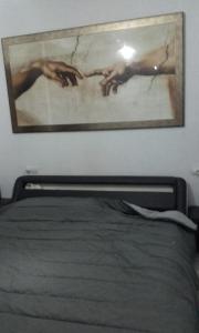 塞维利亚Habitacion privada en un dúplex的卧室上床墙上的画