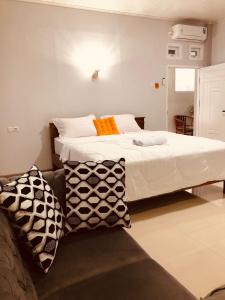 纳闽巴霍La Geiro Villa Labuan Bajo的一间卧室配有一张大床和一张沙发