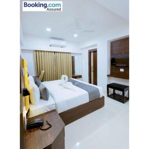 印多尔Hotel Meritel Grande, Vijay Nagar, Indore的一间卧室配有一张大床和电视
