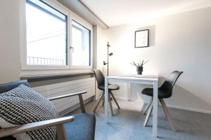圣加仑Grubenmann Appartements - Sankt Gallen Town的客房设有桌椅和窗户。