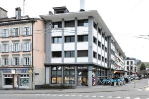 圣加仑Grubenmann Appartements - Sankt Gallen Town的一条城市街道上高大的白色建筑