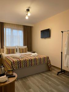 泰拉维Kera Rooms的配有一张床和一台平面电视的酒店客房