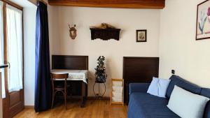 普拉吉拉托Hostdomus - La Posta apartment的客厅配有蓝色的沙发和书桌