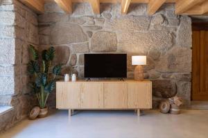 维拉·雷阿尔Casa Da Eira的木柜上的电视,放在石墙里