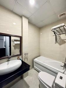 芹苴LION HOTEL的一间带水槽、浴缸和卫生间的浴室
