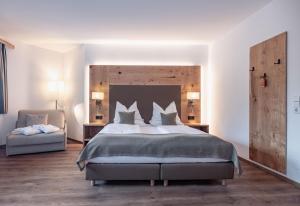 普雷瑟格尔塞阿尔盆亚德里亚酒店 的一间卧室配有一张大床和一把椅子