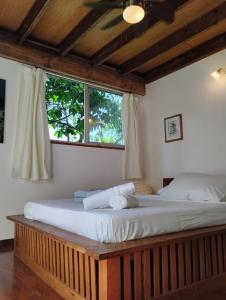 TemaeTema'e Beach House的一间卧室设有一张大床和窗户