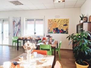 伊索拉迪卡波里祖托Agri B&B Terre Joniche的用餐室配有桌子和绿色椅子