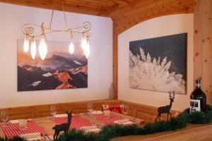 圣莫里茨Hotel Corvatsch的一间设有桌子和墙上绘画的用餐室