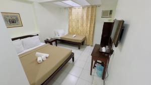 达沃市安克拉酒店的客房设有床、电视和沙发。