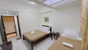 达沃市安克拉酒店的一间小卧室,配有一张床和镜子
