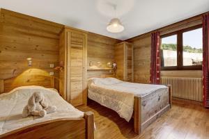大博尔南Les Congères的一间卧室设有两张床,床上配有泰迪熊