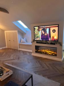哈罗盖特Kiln House Lodge的客厅设有壁炉和平面电视。