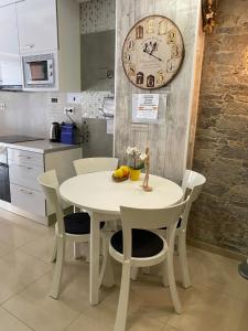 巴达洛纳BADAROSA 2 House10min to BARCELONCity&NearTo BEACH的厨房配有白色的桌椅和时钟