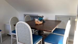ClegganDrop Anchor House, Spacious 3 bedroom apartment, fabulous sea views的一张带蓝色椅子和木桌的餐桌