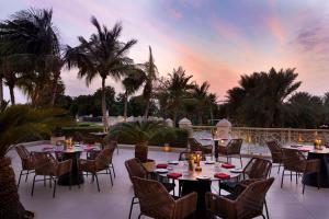 拉斯阿尔卡麦哈伊马角华尔道夫酒店的一个带桌椅的庭院,享有日落美景
