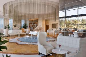 拉斯阿尔卡麦哈伊马角华尔道夫酒店的客厅配有白色家具和大吊灯。