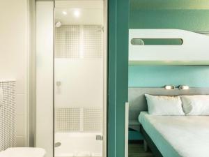 布尔日布尔日宜必思快捷酒店的一间卧室设有一张床和一个玻璃门
