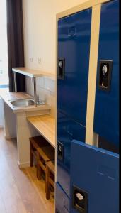 尼斯Hôtel Lyonnais的厨房里摆放着蓝色的橱柜,配有书桌