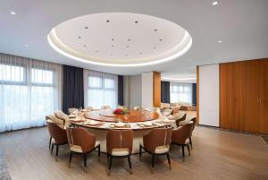 新余新余华侨豪生大酒店的大型会议室,配有大桌子和椅子