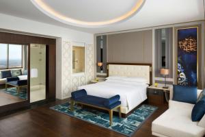阿可贺巴Grand Hyatt Al Khobar Hotel and Residences的一间卧室配有一张床、一把椅子和一张沙发