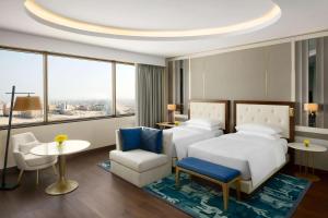 阿可贺巴Grand Hyatt Al Khobar Hotel and Residences的酒店客房带一张床、一张桌子和椅子