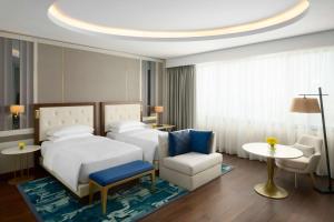 阿可贺巴Grand Hyatt Al Khobar Hotel and Residences的酒店客房,配有两张床和椅子