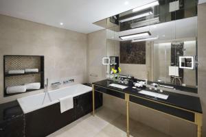 阿可贺巴Grand Hyatt Al Khobar Hotel and Residences的浴室配有2个盥洗盆、浴缸和浴缸。